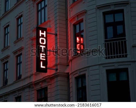 Hotel neon sign glowing in the street in the evening