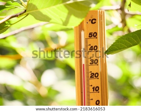 Red heat warning , Heatwave cause climate change and global warming . Thermometer making 30 degrees celsius temperature , extreme hot summer weather in Hungary, Europe. Nature green forest background. Royalty-Free Stock Photo #2183616053