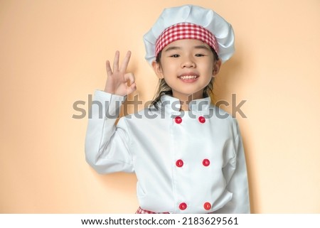 Smiling little asian chief with hat, isolated on orange background