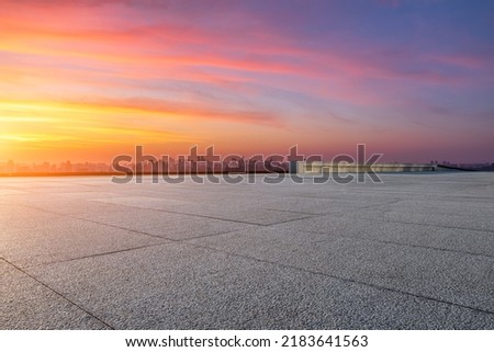 Empty floor and modern city skyline with sky clouds at sunset