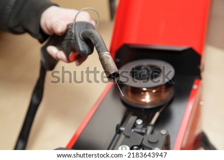 Semiautomatic wire welding machine torch with welding wire open cap close up Royalty-Free Stock Photo #2183643947