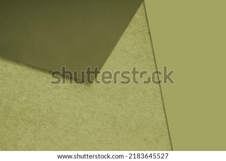 Plain and Textured brown green papers randomly laying to form M like pattern and triangle for creative cover design idea