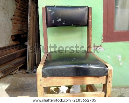 an old chair made of black patterned wood where the seat is