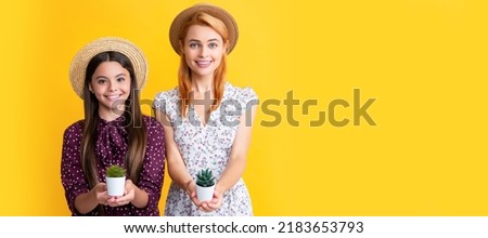 Mother and daughter kid banner, copy space, isolated background. cheerful mother and daughter with plant in pot on yellow background.