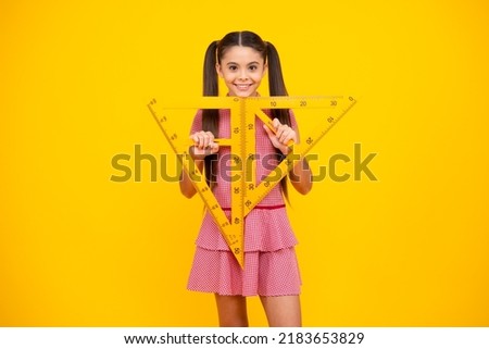 School girl holding measure for geometry lesson, isolated on yellow background. Measuring equipment. Student study math. Happy teenager, positive and smiling emotions of teen schoolgirl.