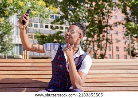 young african american man using his smart phone to take a selfie or make a video call