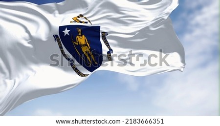 The US state flag of Massachusetts waving in the wind. Massachusetts is the most populous state in the New England region of the United States. Fabric texture background. Royalty-Free Stock Photo #2183666351