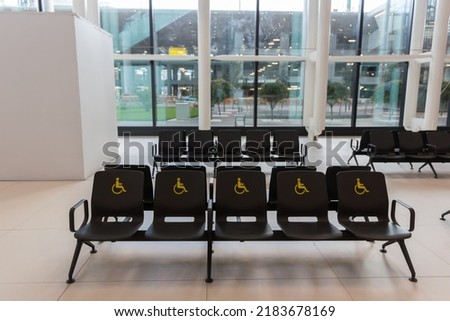 Reserved seats and signs for people with disabilities at Istanbul Airport terminal, Turkiye Royalty-Free Stock Photo #2183678169