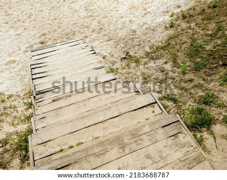 descent to the beach by wooden stairs. wooden stairs to the beach. Wooden steps. Royalty-Free Stock Photo #2183688787