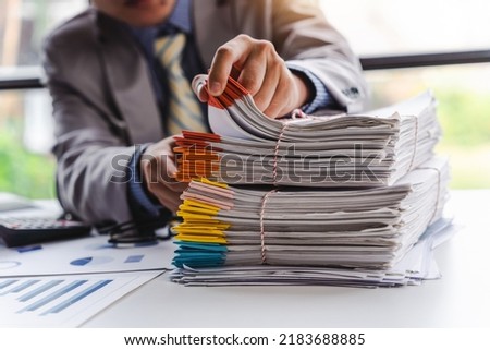 Stack of documents, pile of papers on office desk employee's table, closeup, Asian people. Royalty-Free Stock Photo #2183688885