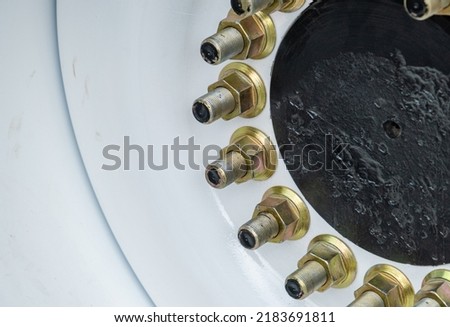 Fasteners and bolts on a car, bolts and nuts on car tires, clips on metal, parts and spare parts for trucks. car wheel nuts Royalty-Free Stock Photo #2183691811