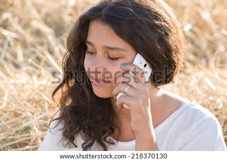 Teen girl talking on the phone outdoors