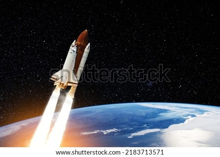 Spaceship lift off. Space shuttle with smoke and blast takes off into the starry sky. Rocket starts into space. Concept. Elements of this image furnished by NASA. Royalty-Free Stock Photo #2183713571
