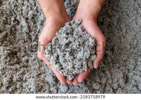 Close shot of eco friendly cellulose insulation filling held in hand  Royalty-Free Stock Photo #2183718979