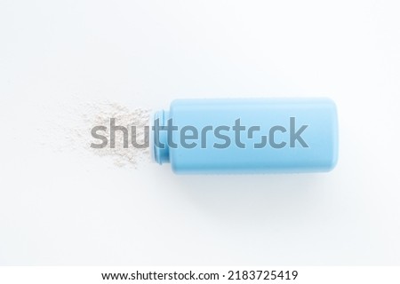 Talcum powder in container. Spilled white powder Royalty-Free Stock Photo #2183725419