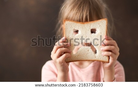 diet celiac. gluten intolerance. sad bread in the hands of a child. Gluten free concept  Royalty-Free Stock Photo #2183758603
