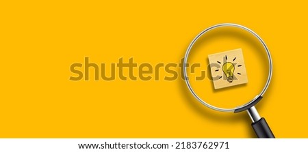 Creative idea concept, magnifying glass and light bulb icon on wooden block with yellow background Royalty-Free Stock Photo #2183762971