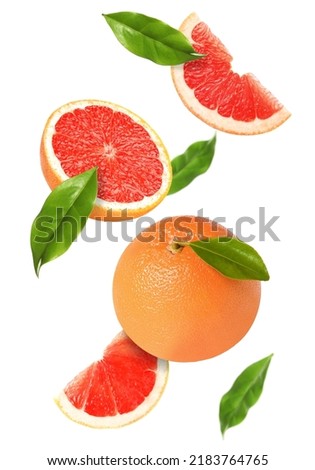 Tasty ripe grapefruits and green leaves falling on white background Royalty-Free Stock Photo #2183764765
