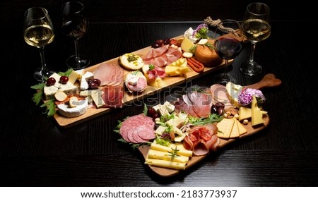 Wine and charcuterie and cheese board with a place for text. Prosciutto di Parma ham, blue cheese. Italian appetizers or antipasto set with gourmet food on table top view. Mixed delicatessen Royalty-Free Stock Photo #2183773937