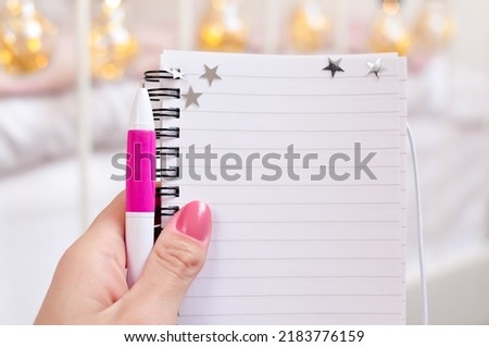 Notebook in hand with stars and pink pen for notes copy space. High quality photo