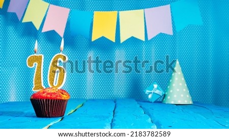 Happy birthday card with a muffin decorated with a festive cake and burning candles. Copy space. Beautiful background happy birthday on the background of blue boards with a number of candles number 76