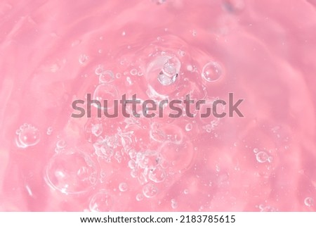 Abstract background. The texture of the waves on a pink background. Bubbling water, splashes and drops.