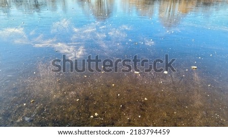 View over frozen lake with reflection of blue sky in clear weather