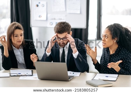 Annoyed business employees of different nationalities, work at the workplace in modern office, argue over work issues, cannot agree, experience stress from working together. Quarrel in the work team Royalty-Free Stock Photo #2183805257