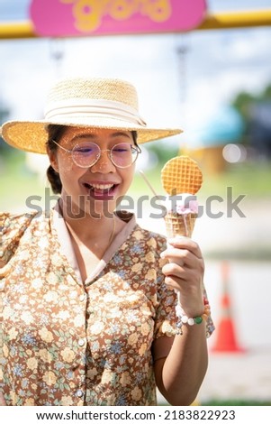 Bruntte girl holding Ice Cream at Sweet Candy Deserts Land on Fluffy Clouds, Woman with Icecream Cone fresh fressz cool and verry good tasty Home made ice cream on Summer day at Icecream land