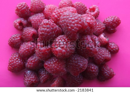 Top view of a pile of raspberries, on a pink background. Royalty-Free Stock Photo #2183841