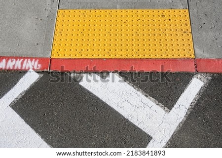 Freshly painted white crosswalk marking leading to a yellow painted ADA sidewalk access in a fire lane
 Royalty-Free Stock Photo #2183841893