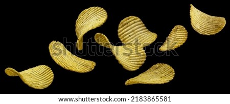Ridged potato chips isolated on black background Royalty-Free Stock Photo #2183865581