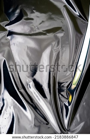 Blank glued aluminum foil texture for background and wallpaper. Crumpled abstract texture surface from wrapping paper. Wrinkled shiny silver foil for banner, poster, overlay and design element. Royalty-Free Stock Photo #2183886847