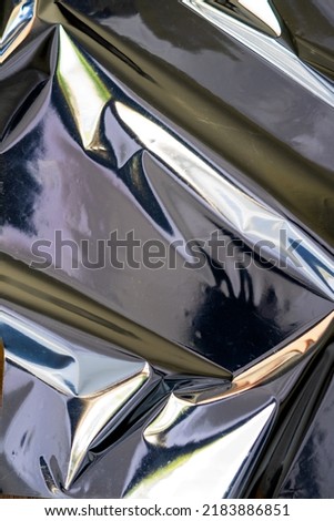 Blank glued aluminum foil texture for background and wallpaper. Crumpled abstract texture surface from wrapping paper. Wrinkled shiny silver foil for banner, poster, overlay and design element. Royalty-Free Stock Photo #2183886851