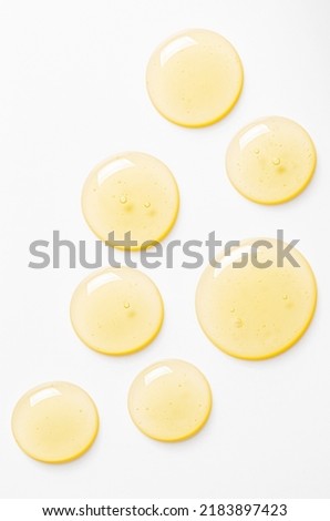 Yellow drops of gel close up. Cosmetic product for moisturizing the skin of the face or body. Royalty-Free Stock Photo #2183897423