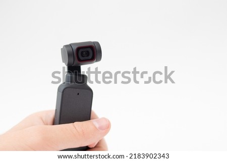 Man hand holding Action Camera video gimbal stabilizator on white background.