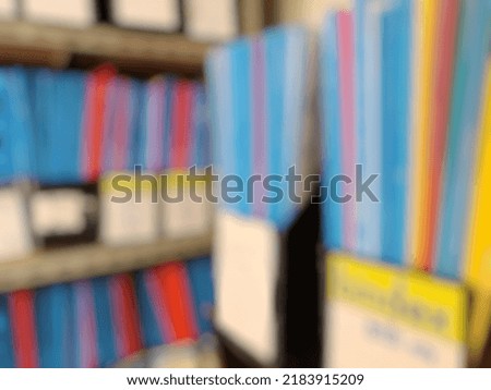 Blur Photo of a collection of documents with colorful covers arranged on a shelf 