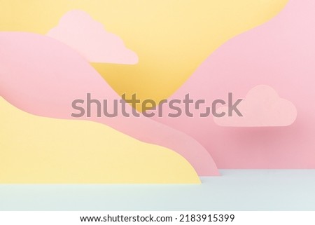 Abstract colorful empty stage mockup - paper landscape with mountains yellow, mint color with pink clouds in baby cartoon naive style. Art background for presentation of cosmetic produce, gift, goods.