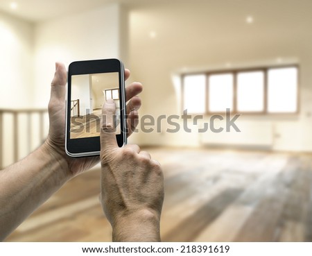 Mobile device with man hands taking picture in modern loft studio