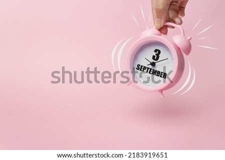 September 3rd. Day 3 of month, Calendar date. The morning alarm clock jumping up from the bell with calendar date on a pink background.  Autumn month, day of the year concept