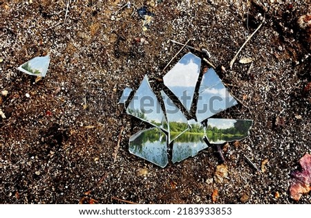 Broken glass with lake next to the forest background on the ground - photo with theme unfavorable weather in spring summer , unfulfilled dream , trip Royalty-Free Stock Photo #2183933853