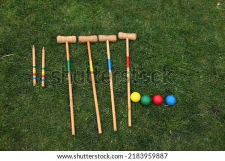 Set of croquet equipment on green grass, flat lay Royalty-Free Stock Photo #2183959887