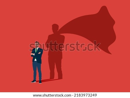 Businessman dreams of becoming a superhero. Confident handsome young man standing superhero shadow concept illustration. Royalty-Free Stock Photo #2183973249