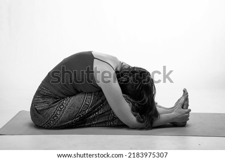 Sporty woman doing exercises on a rubber carpet in black and white