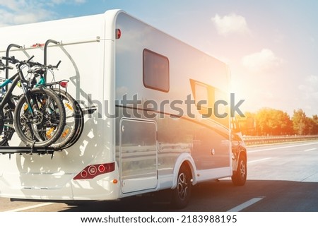 Scenic view big modern white family rv camper van vehicle driving on european highway road against blue sky in summer day. Rving motorhome lifestyle travel and adventure tourism trip journey concept Royalty-Free Stock Photo #2183988195