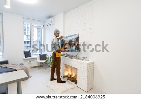 repairman master holds a photo canvas