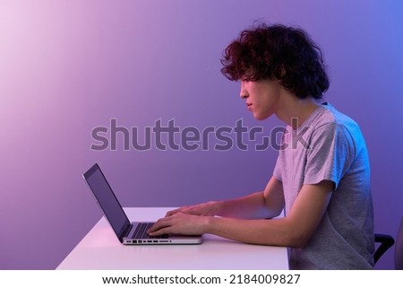 guy cyberspace playing with in front of a laptop violet background