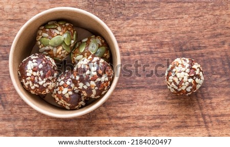 Selective focus picture of Power ball nutrition, homemade from chocolate, peanut, almond, cashew, sunflower seed,  sweet taste, healthy food, serve in papaer box on wood table. Food issue. 