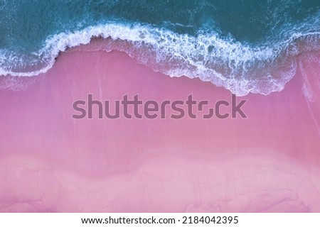 Beach Sand Sea Shore and waves white foamy summer sunny day background.Amazing pink beach top down view overhead seaside nature background