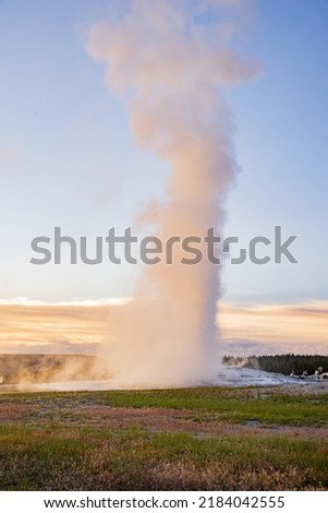 Sunset view of the Old Faithful geyser at Wyoming Royalty-Free Stock Photo #2184042555
